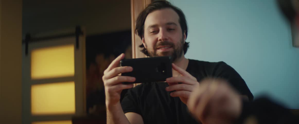 A man is taking a picture of someone with his cell phone