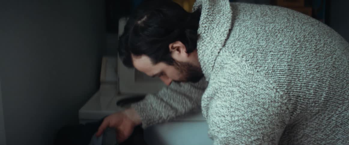 Man putting laundry inside a washing machine at home