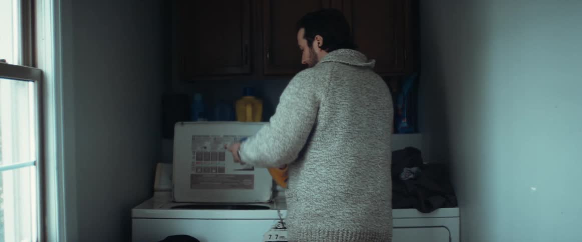 A man is doing laundry in his house