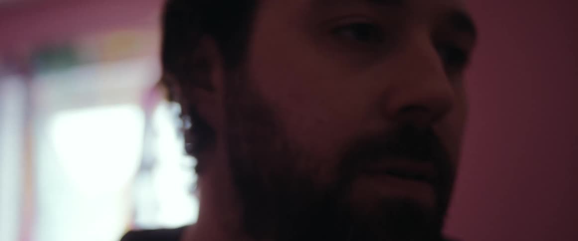 Bearded man nervously searching through the furniture in a room at home
