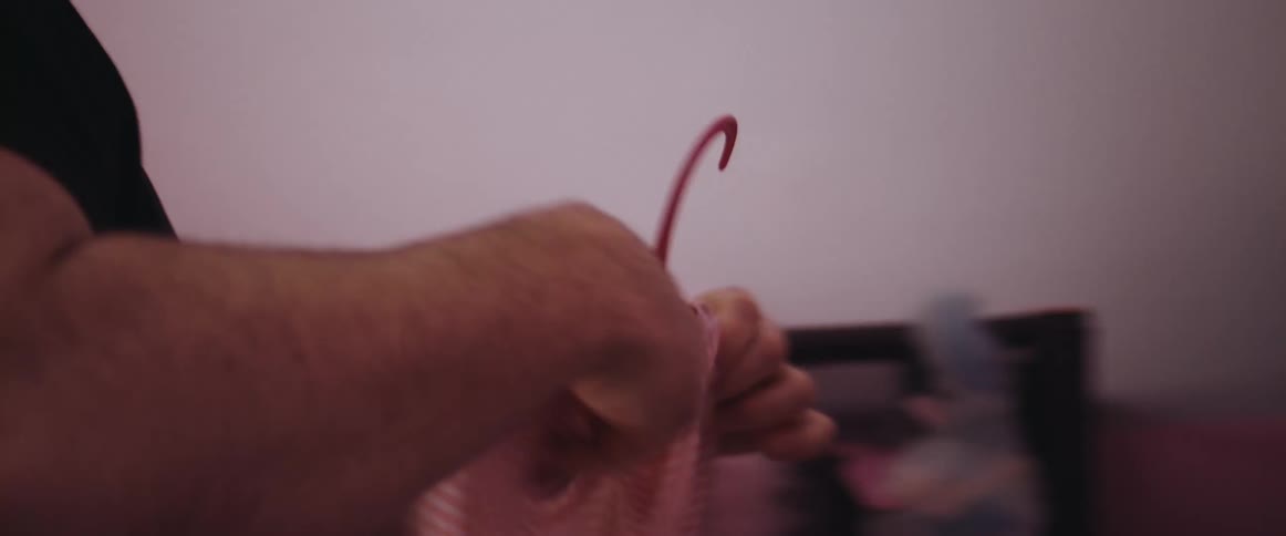 A man at home hangs up a young childs clothing