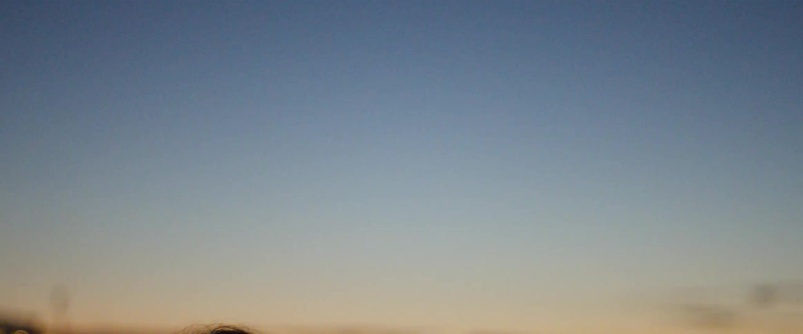 Young couple running on the shores of a lake at sunset