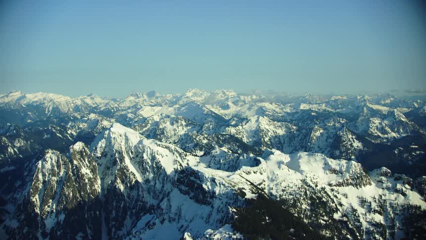 Snow covered mountains under a hazy blue sky