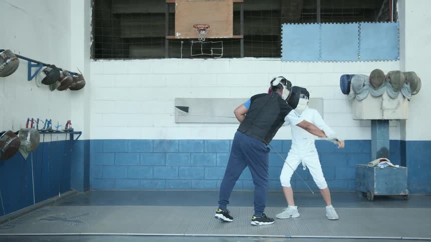 A man instructs a child in fencing