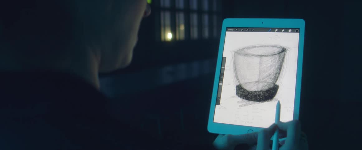 A person drawing a cup on a tablet