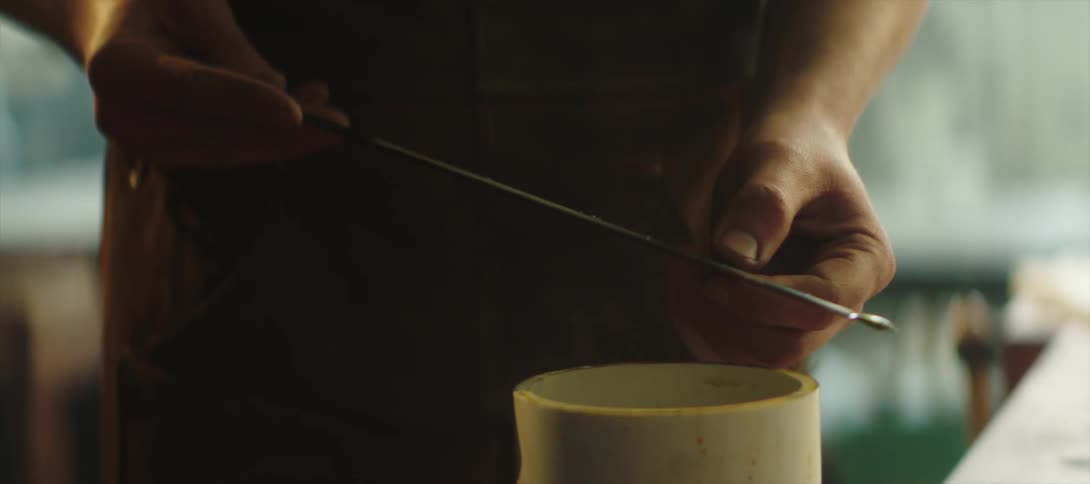 A blacksmith is putting oil on a blade