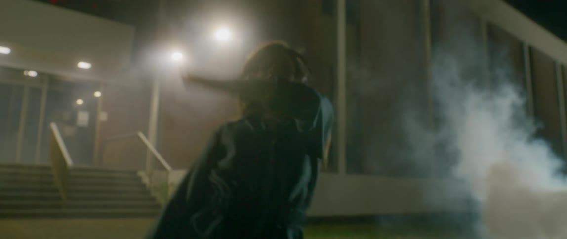 A girl is dancing outside as smoke rises