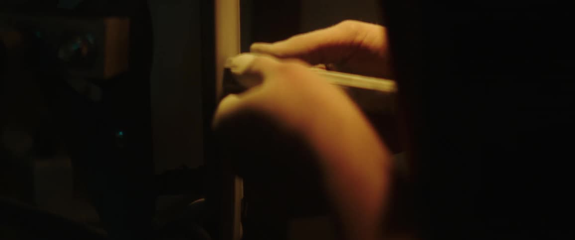A person is shaving a metal rod on a grinder