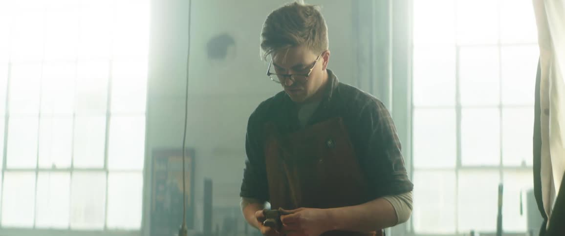 A man in a workshop sands