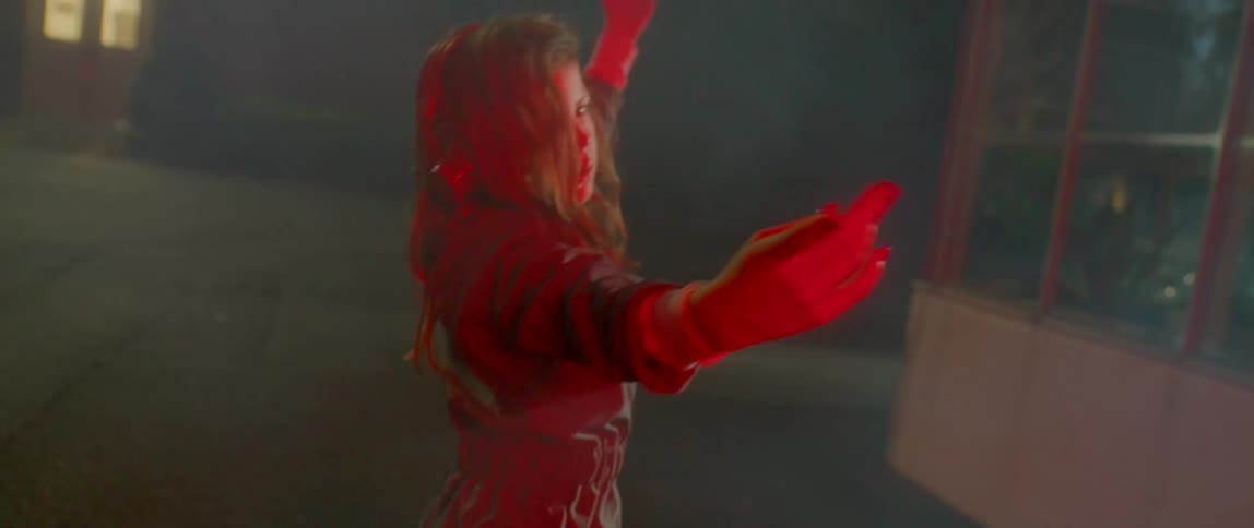 A woman with headphones dancing in a room with smoke