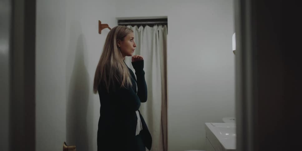 A woman is pacing nervously in the bathroom