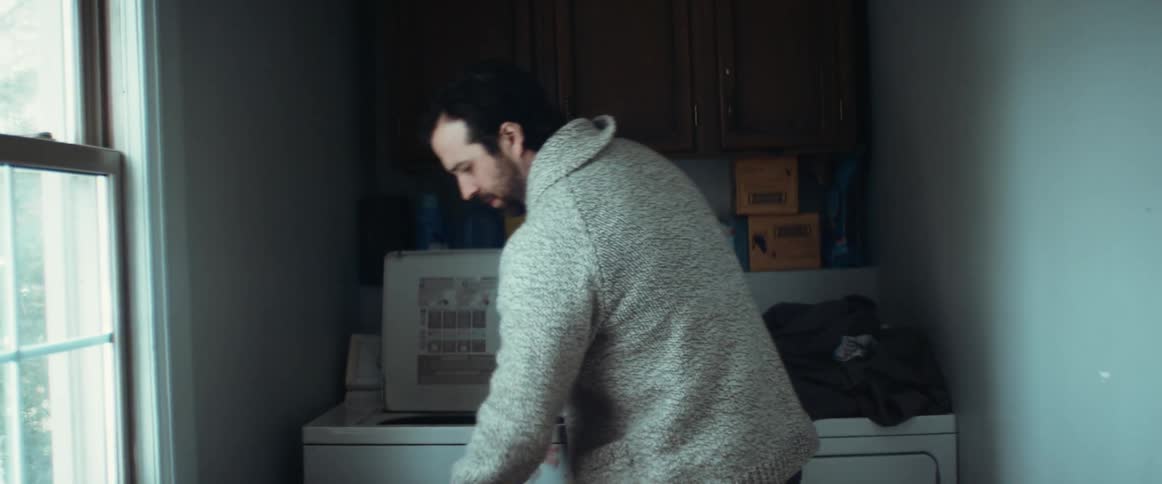 A man loads clothing into the washing machine