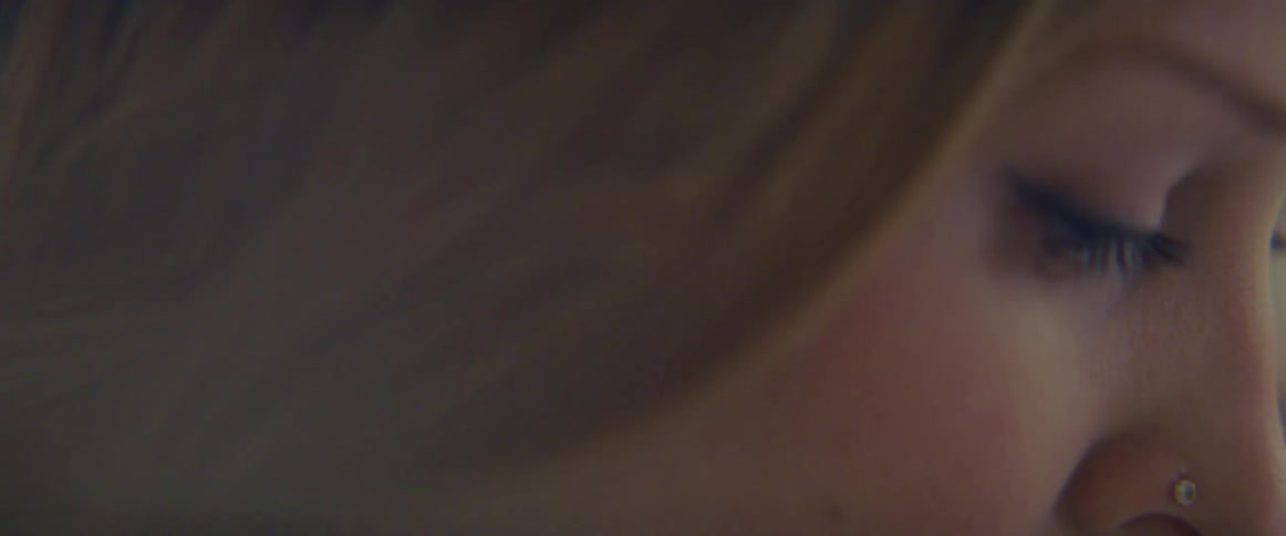 Side view of blonde woman with nose ring looking down