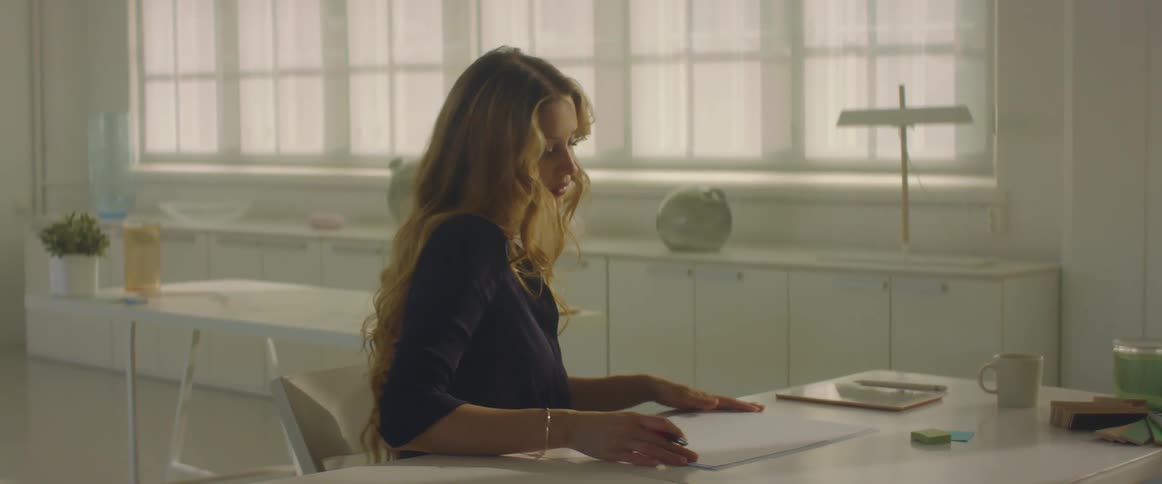 Woman sitting at a desk in the office gets ready for work