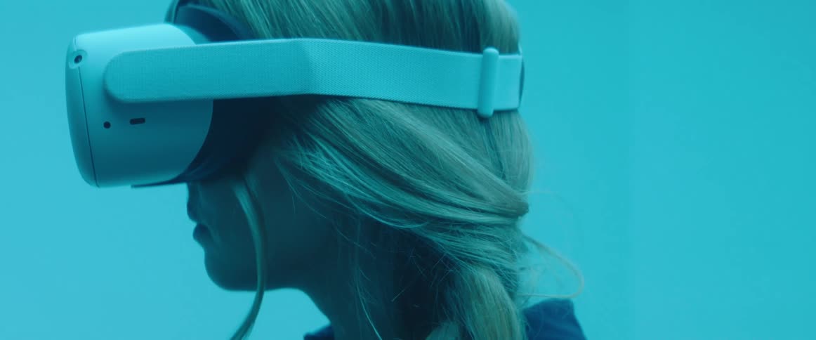 A woman using a white virtual headset indoors