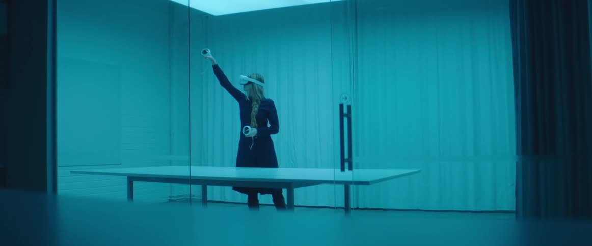 A woman is using controllers with a virtual reality headset