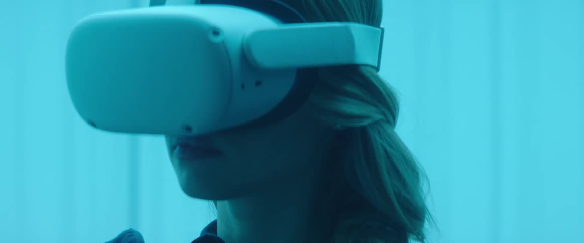 A woman is looking through a virtual reality headset
