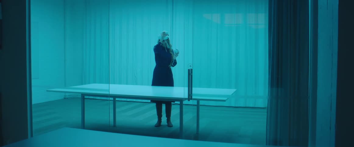A woman is using a virtual reality headset near a large table