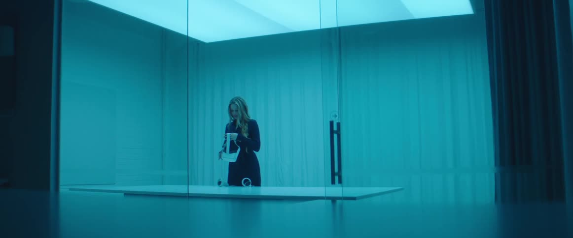 A woman walks in to a room and puts on a virtual reality headset