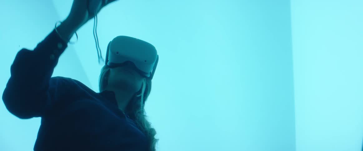 A woman is using a virtual reality headset and controllers