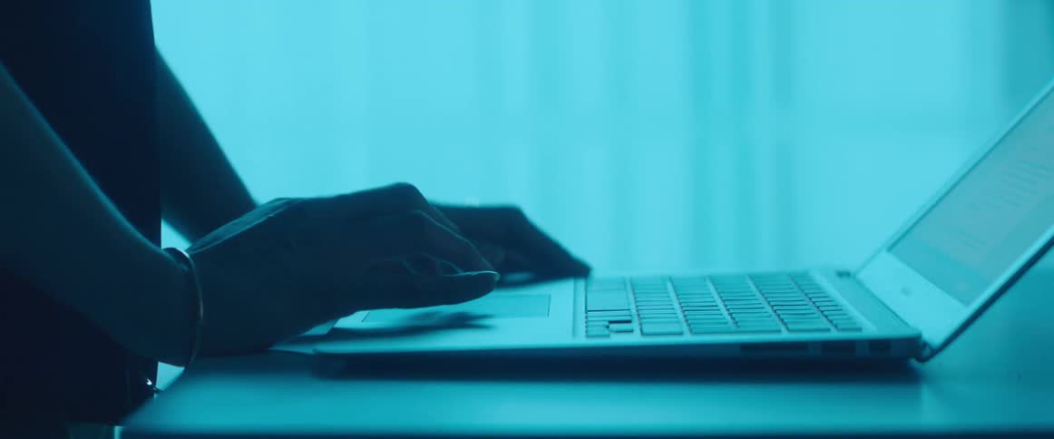 A woman is using a laptop in the dark room