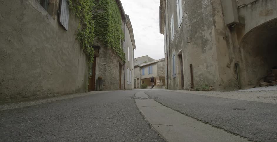 A person rides a bike in an alley uphill