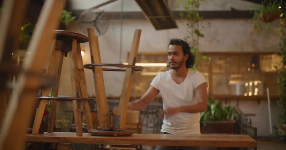 An employee taking chairs off a table