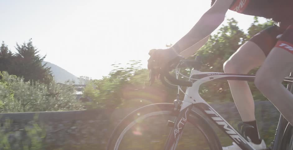 A man is riding a bike along a green field