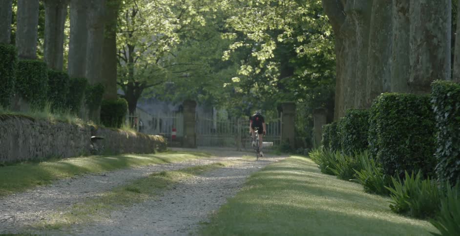 A man rides a bike over a gravel path