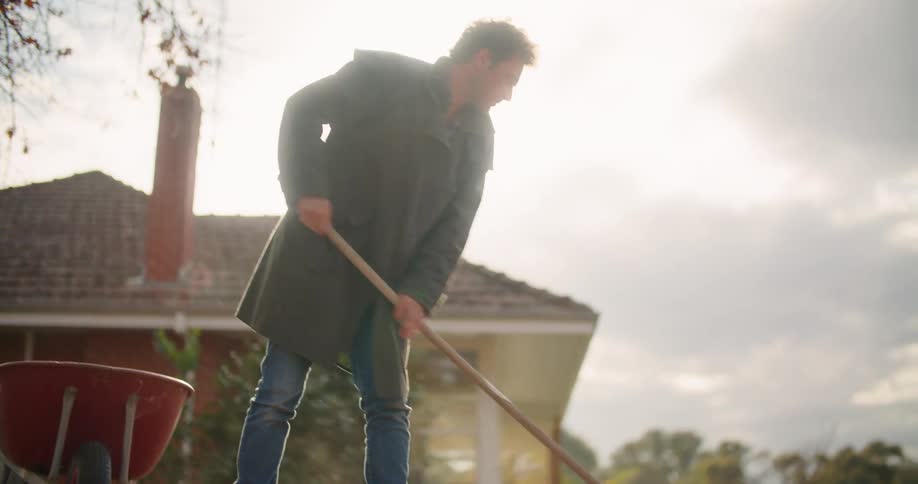 A man raking leaves on a field