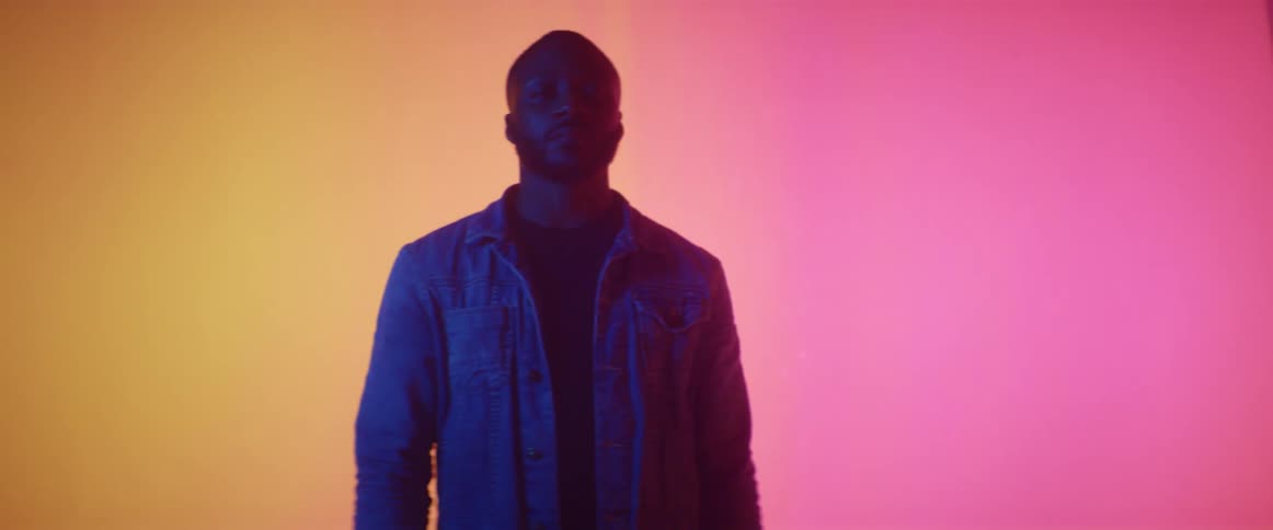 A man is posing in front of some lights