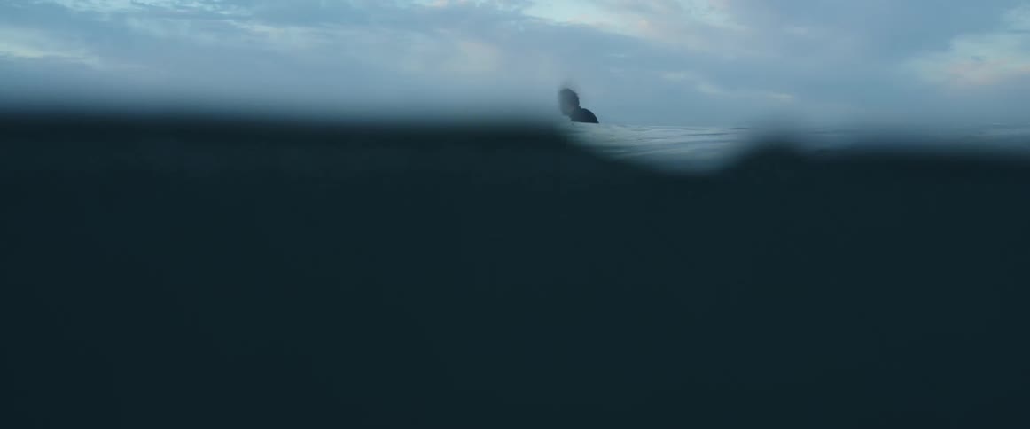 A man in the ocean as waves go around him