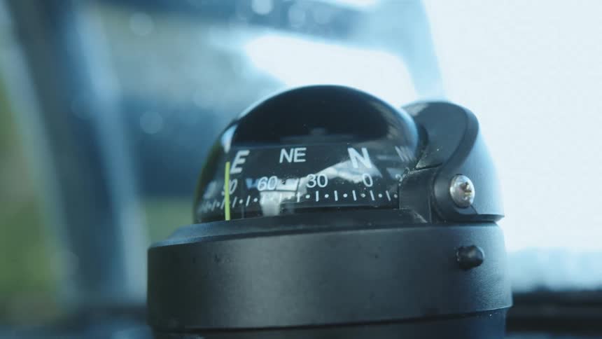 A black sphere compass device moving slightly on a flat surface