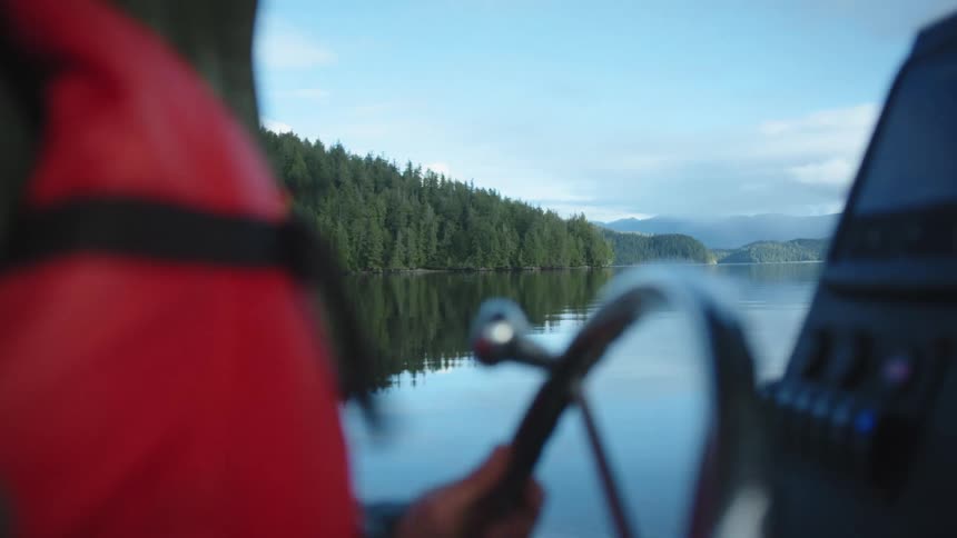 A person is steering a boat around an island