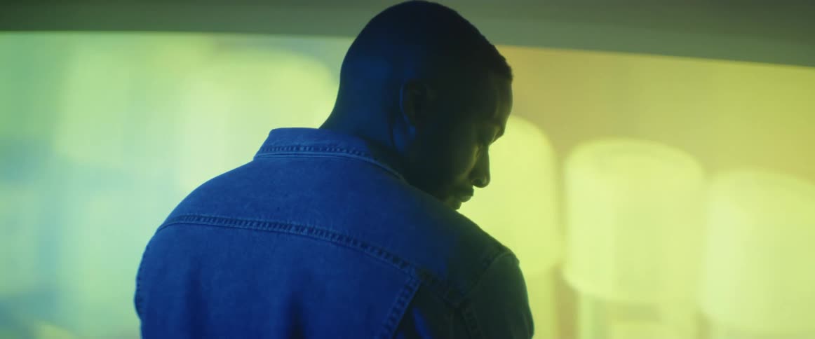A man is standing in a room by a digital display