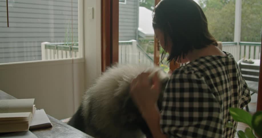 A woman sitting with her dog on a porch
