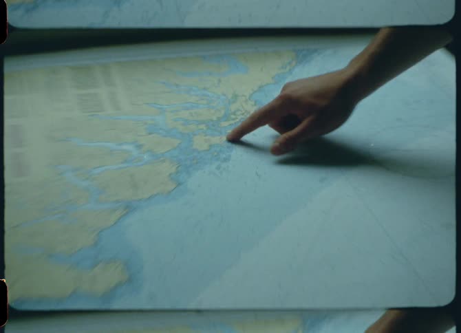 A finger pointing to locations on a table map