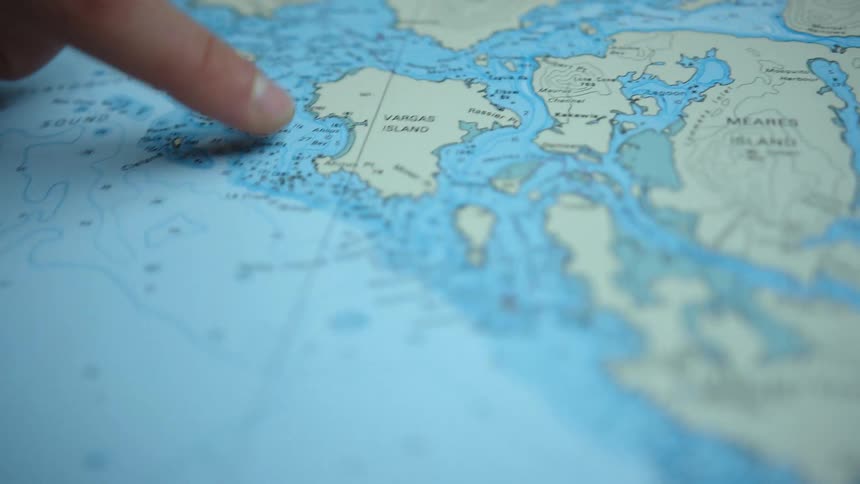 A person pointing at a country on a map