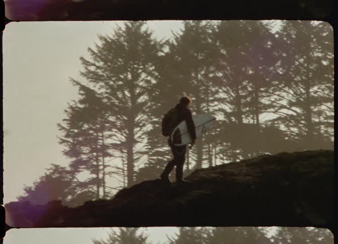 A man hikes over the rocks by the shore