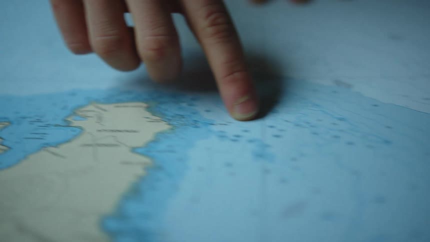 A teacher pointing at items on a map
