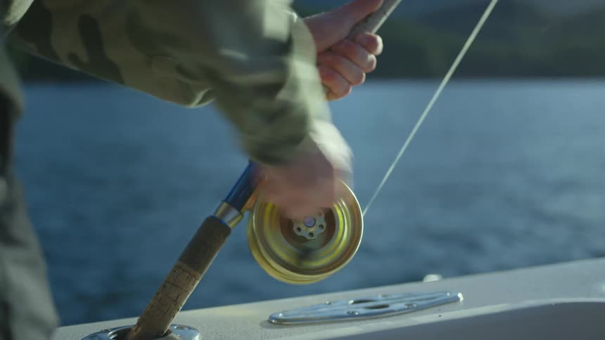 A person reeling in on a fishing rod