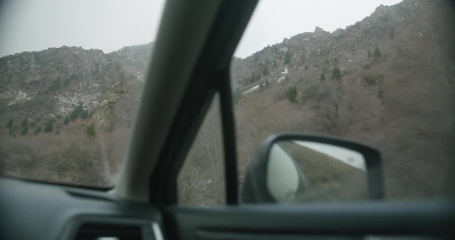 A vehicle drives past a mountain range
