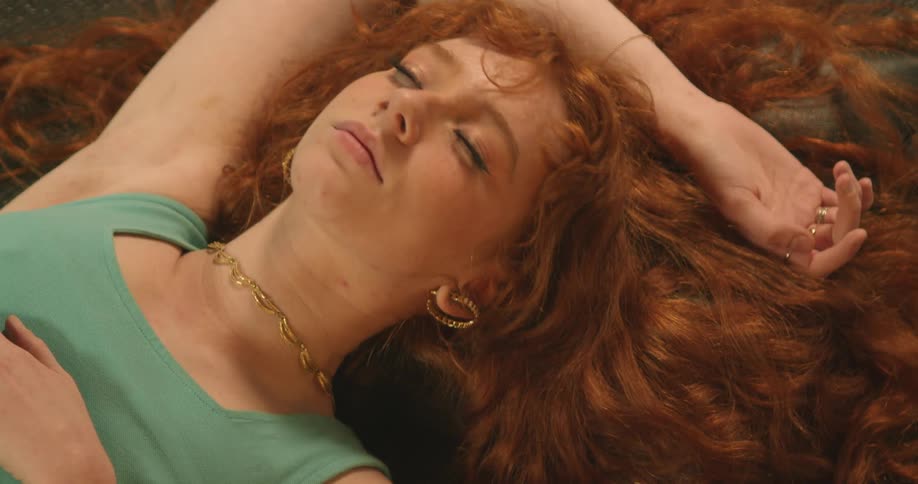 A woman is laying down and wearing jewelry