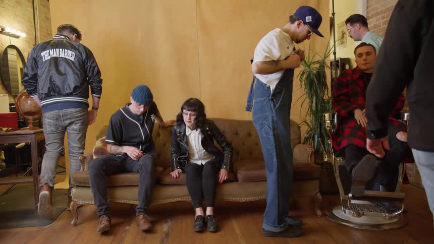 A group of people pose for a picture in a barber shop