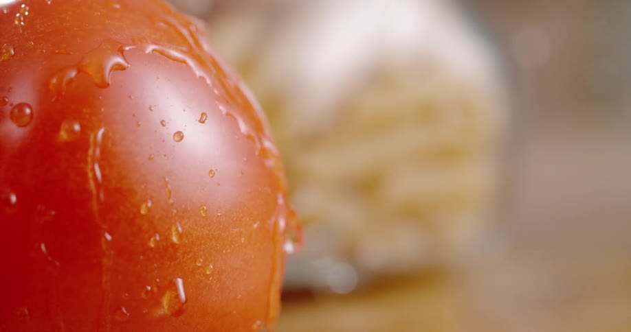 A tomato in a room with water dropping on it