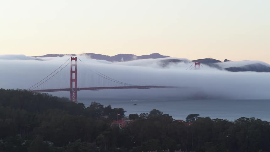 Bridge sits over the lake near the mountains as birds fly overhead