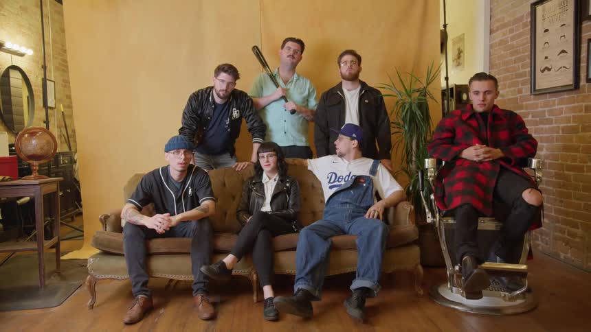 A group of people sit and stand together posing for a photograph