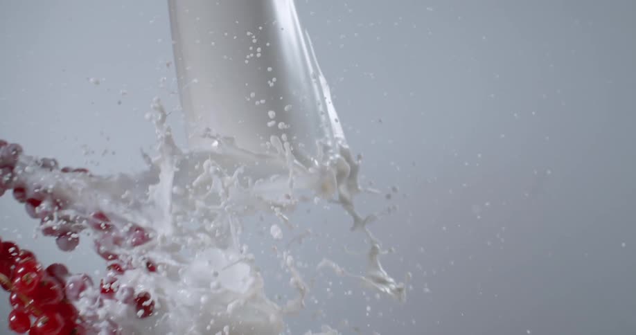 Grapes flying through a flowing white liquid
