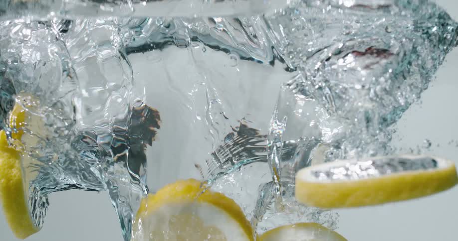 Lemon slices falling into clear water