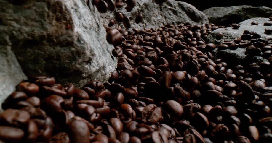 Roasted coffee beans sliding and piling over rocks